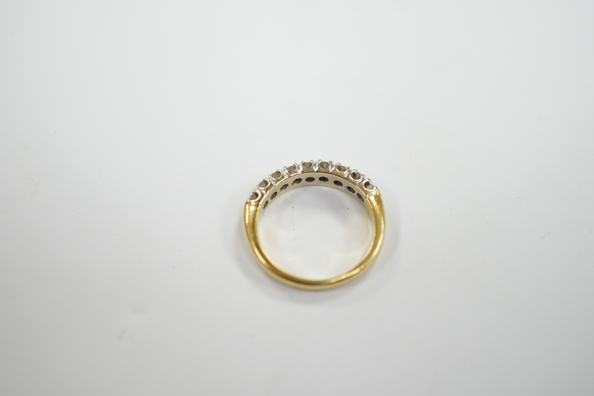 A modern 750 yellow metal and nine stone diamond chip set half hoop ring, size I/J, gross weight 3.1 grams.